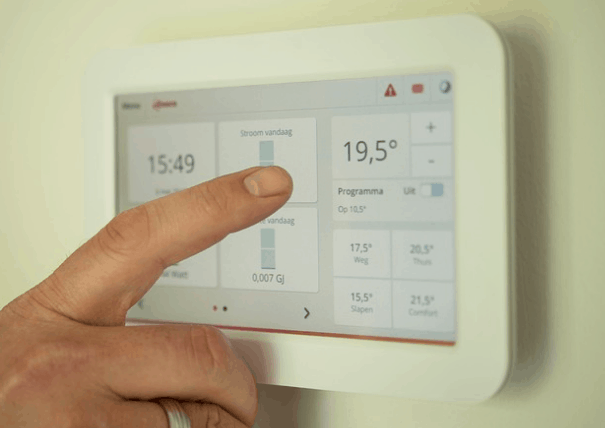 Adjusting the thermostat on a home HVAC system.