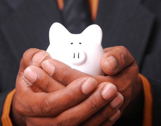 A iggy bank in hand from an emergency savings.