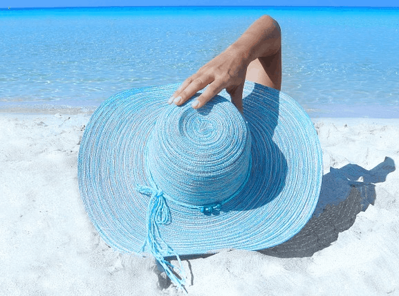 A woman on a beach who saved money for a trip.