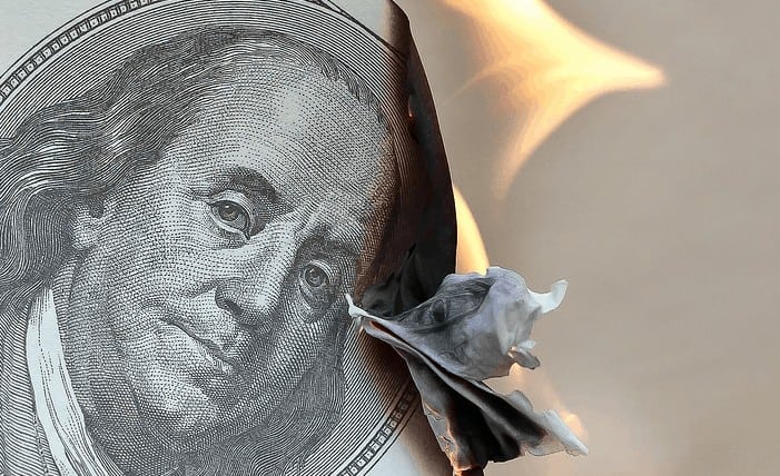 An image of burning money being wasted.
