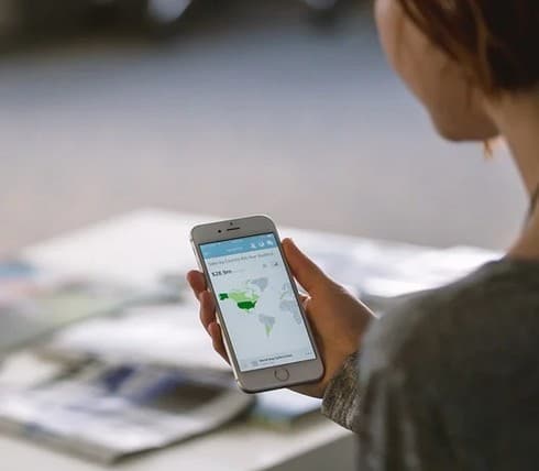 A woman holding a cellular phone.